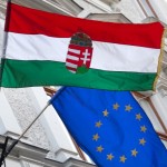 Hungarian and EU flags fly outside a building in central Budapest