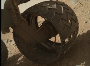 A puncture (centre right) in one of Curiosity's wheels. The sequence of cutouts in the lower right are deliberate and imprint 'JPL' in Morse code as the wheels roll across the Martian surface. 